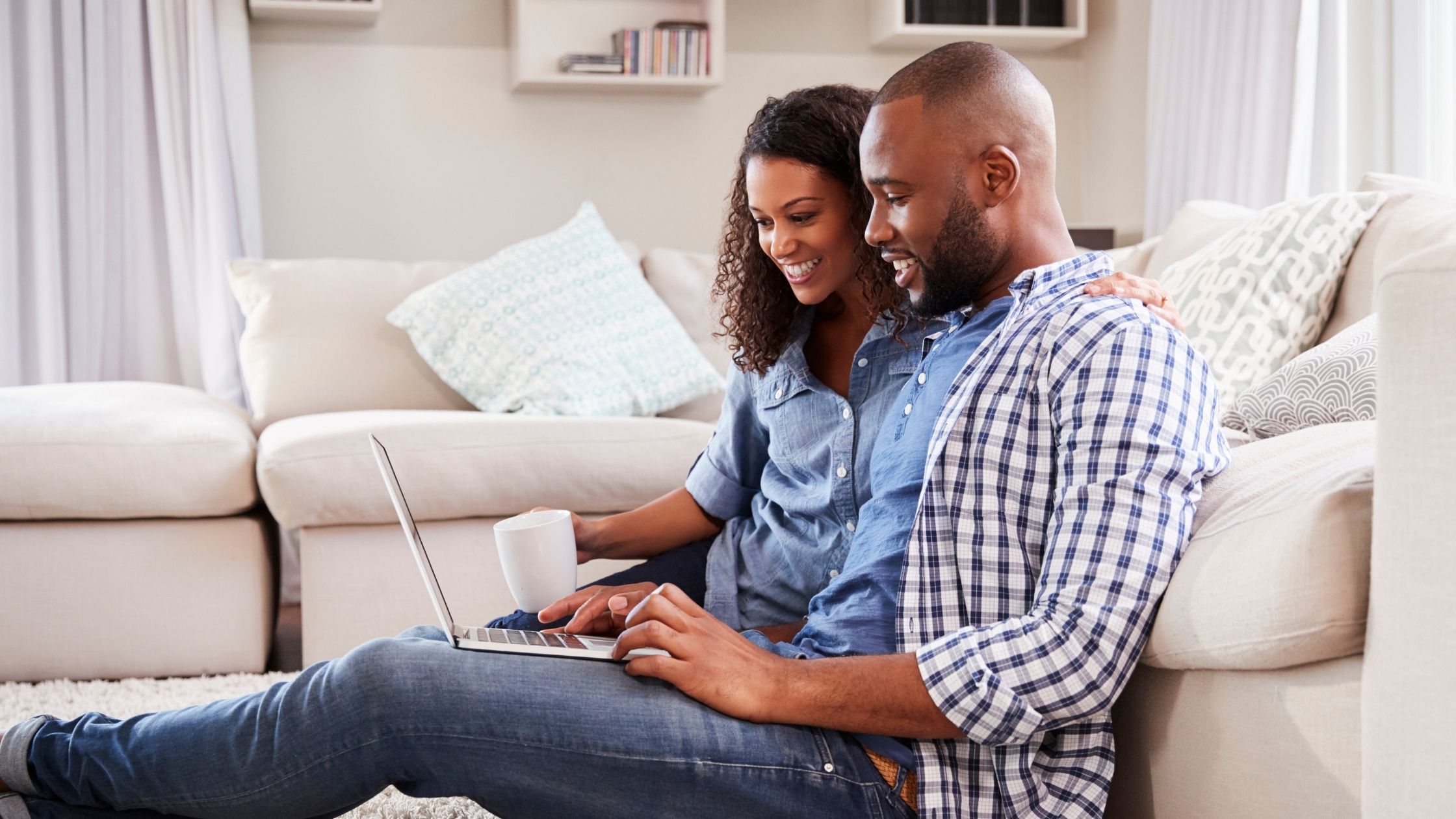 Happy couple looking at money on computer