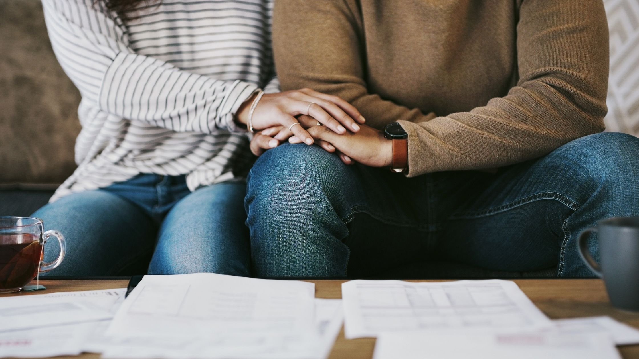 Couple holding hands and discussing money issues